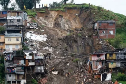 Emergency workers and villagers at the site of a landslide in Marakwet East, western Kenya, searching for survivors amid mud and debris.
