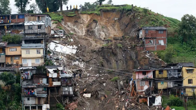 Emergency workers and villagers at the site of a landslide in Marakwet East, western Kenya, searching for survivors amid mud and debris.