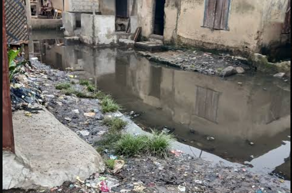 Thick smoke from burning refuse and vehicle exhaust fills the air in a busy Lagos street, highlighting worsening air pollution in the city.
